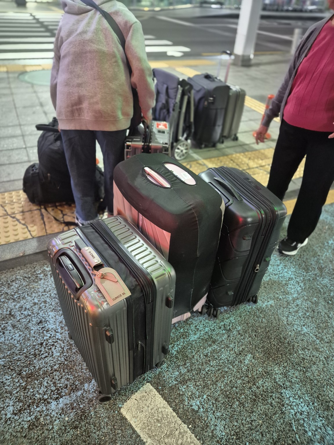 공항 출발층에서 하차 후 일행과 함께 놓인 여행가방